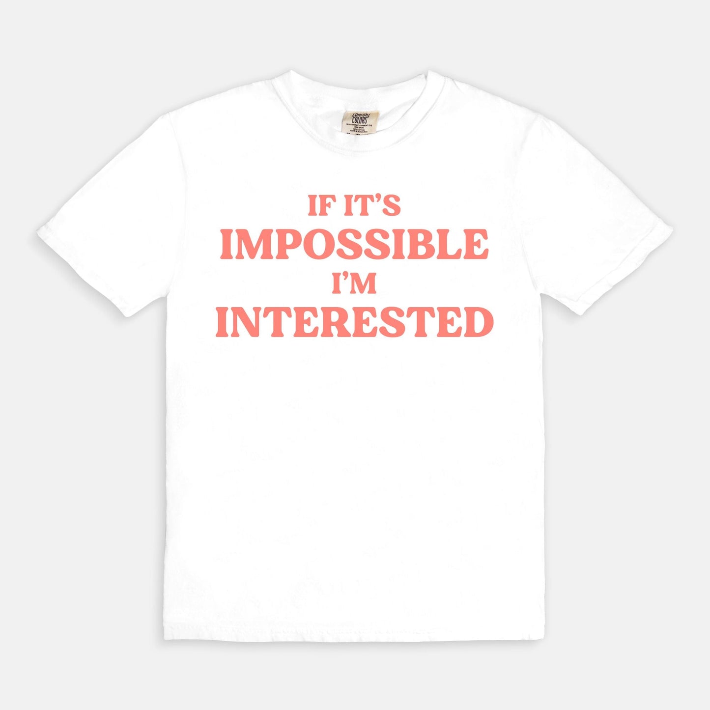 Shop the If It's Impossible I'm Interested T-Shirt in White. Free shipping. Buy today at Up & Comer!