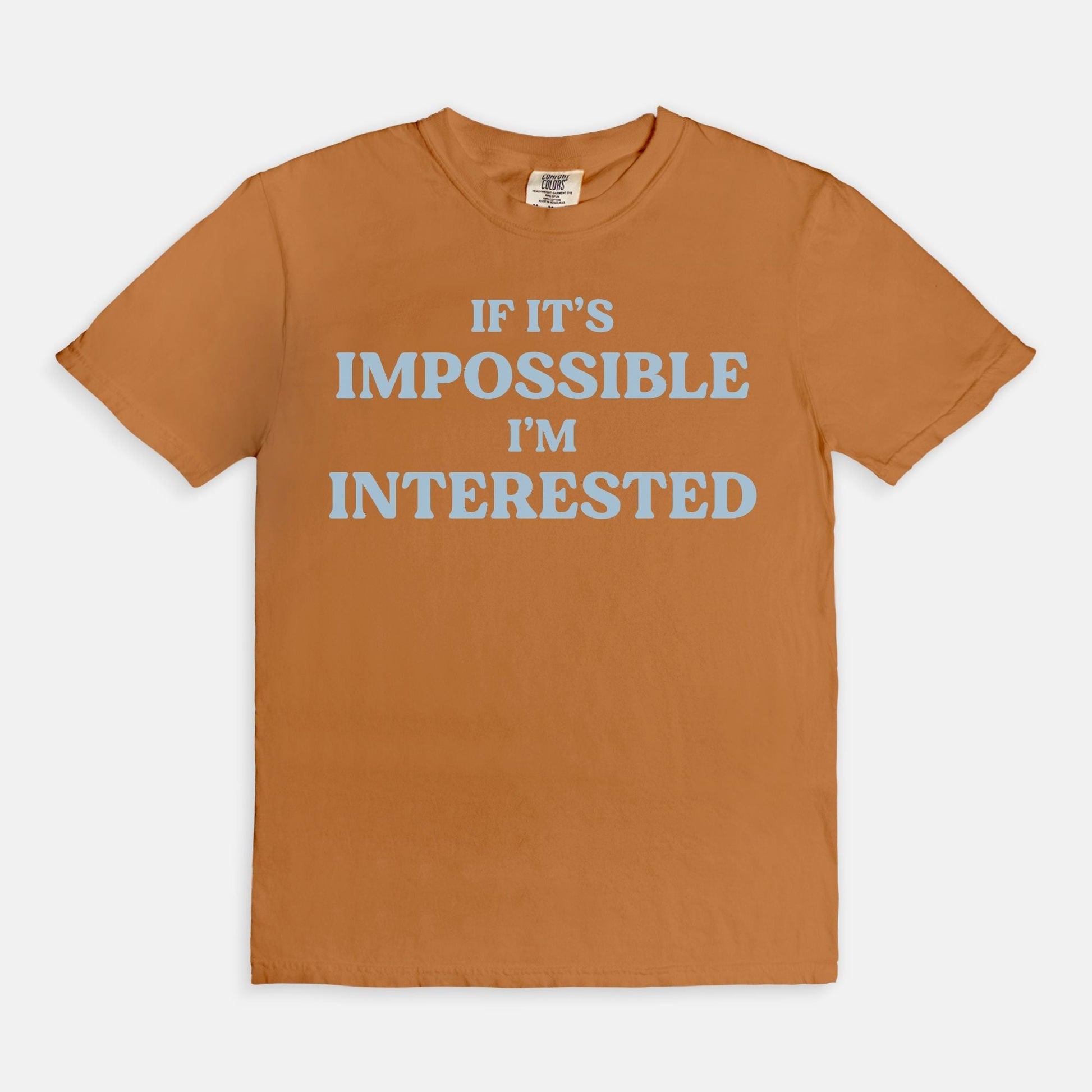 Shop the If It's Impossible I'm Interested T-Shirt in Yam. Free shipping. Buy today at Up & Comer!