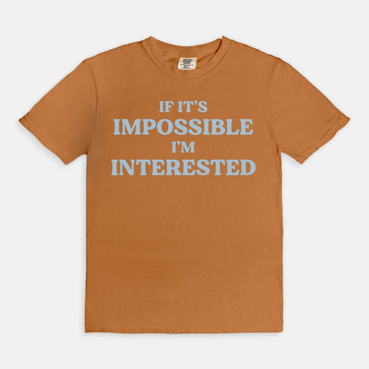 Shop the If It's Impossible I'm Interested T-Shirt in Yam. Free shipping. Buy today at Up & Comer!