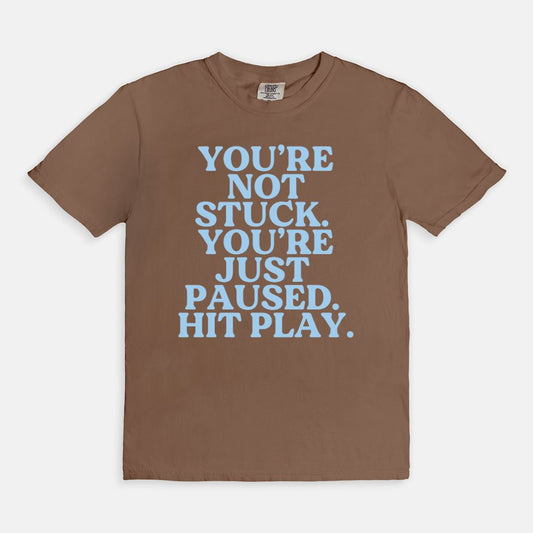 Shop the You're Not Stuck You're Just Paused Hit Play T-Shirt in Espresso. Free shipping. Buy today at Up & Comer!